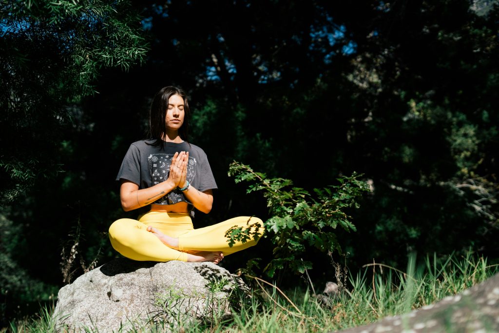 Woman meditating on rock